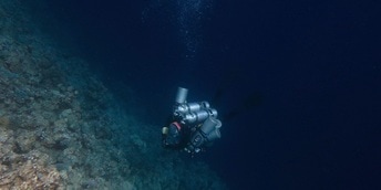 Diver descending deep into the ocean