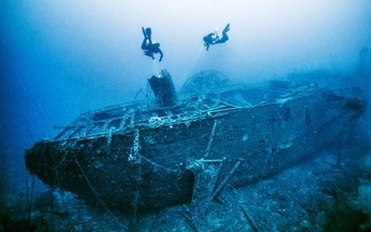 Divers diving around a shipwreck